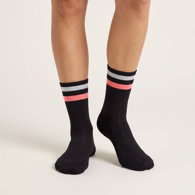 Two Stripe mid-length cycling socks on feet, front view, black with a pale grey and a pink stripe at the cuff